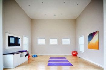 a room with a television and a yoga mat  at Prairie Creek Apartments & Townhomes, Kansas, 66219